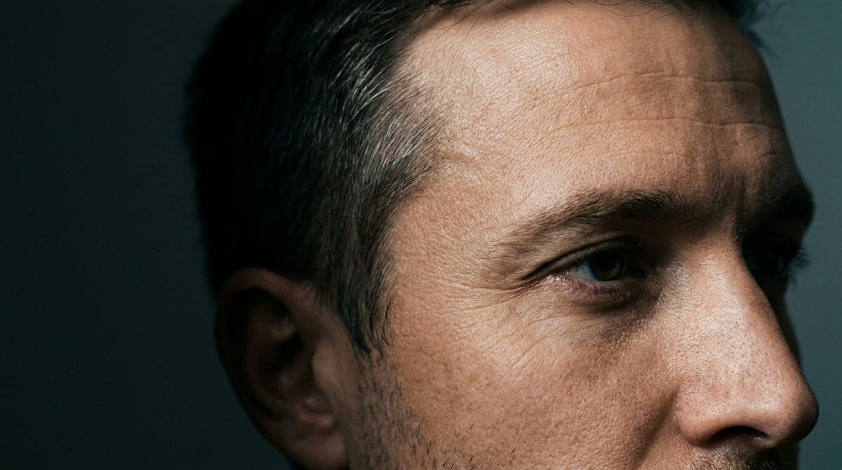 Close-up of a man in his thirties showing early fine lines at the corner of the eye