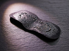 Macro of a used charcoal pore strip on dark slate